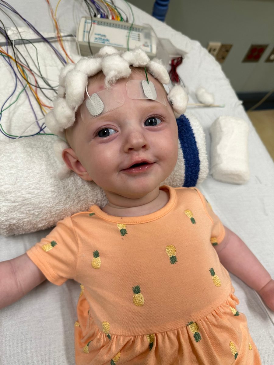 Callie smiling in a hospital bed during an EEG