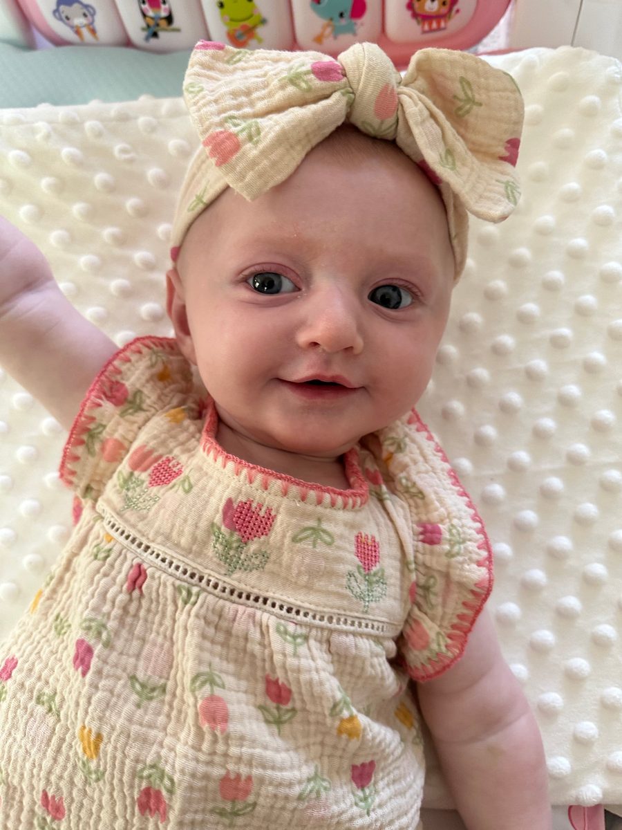 Callie smiling in a tulip dress and bow
